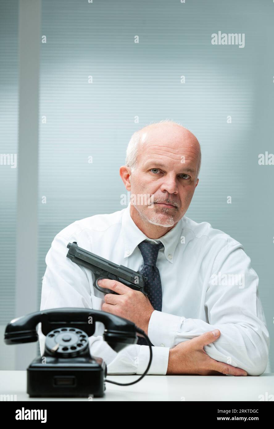Selective blur between contractor killer's phone and the man with a gun. Concept of a hitman waiting in a seemingly governmental office. Essential yet Stock Photo