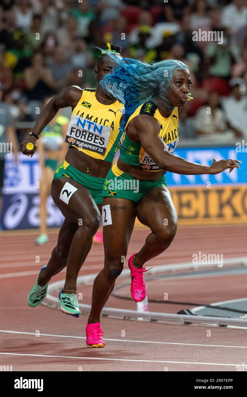 Budapest, Hungary. 25th Aug, 2023. Shashalee Forbes (L) of Jamaica passes the baton to her teammate Shelly-Ann Fraser-Pryce during the heats of women's 4X100 meters relay during the World Athletics Championships in Budapest, Hungary, Aug. 25, 2023. Credit: Meng Dingbo/Xinhua/Alamy Live News Stock Photo