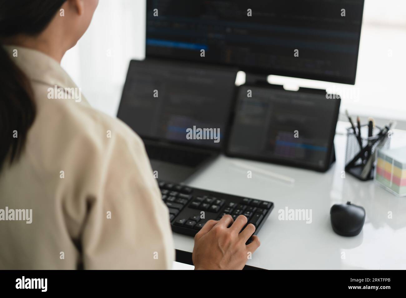 Developer programmer working about programming code to developing web and apps on multiple monitor. Stock Photo