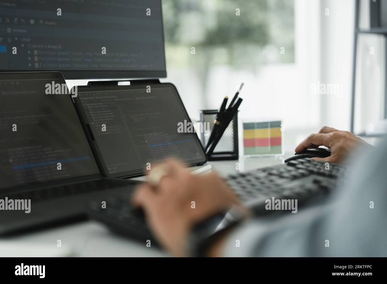 Developer programmer checking code on multiple monitor while programming to developing web and apps. Stock Photo
