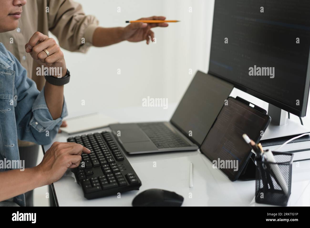 Two developer programmer discussing to checking code on monitor about programming to developing web. Stock Photo