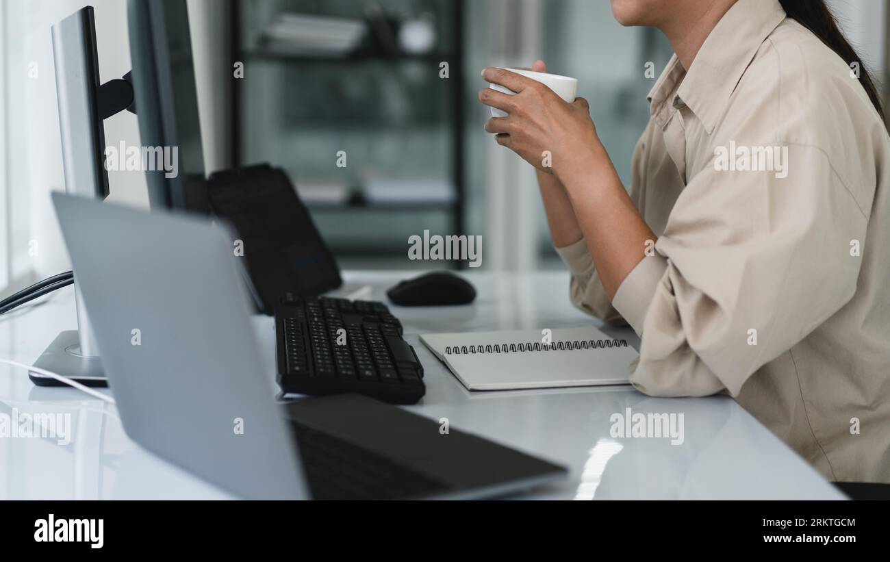 Developer programmer drinking coffee and checking code on monitor for programming to developing web. Stock Photo