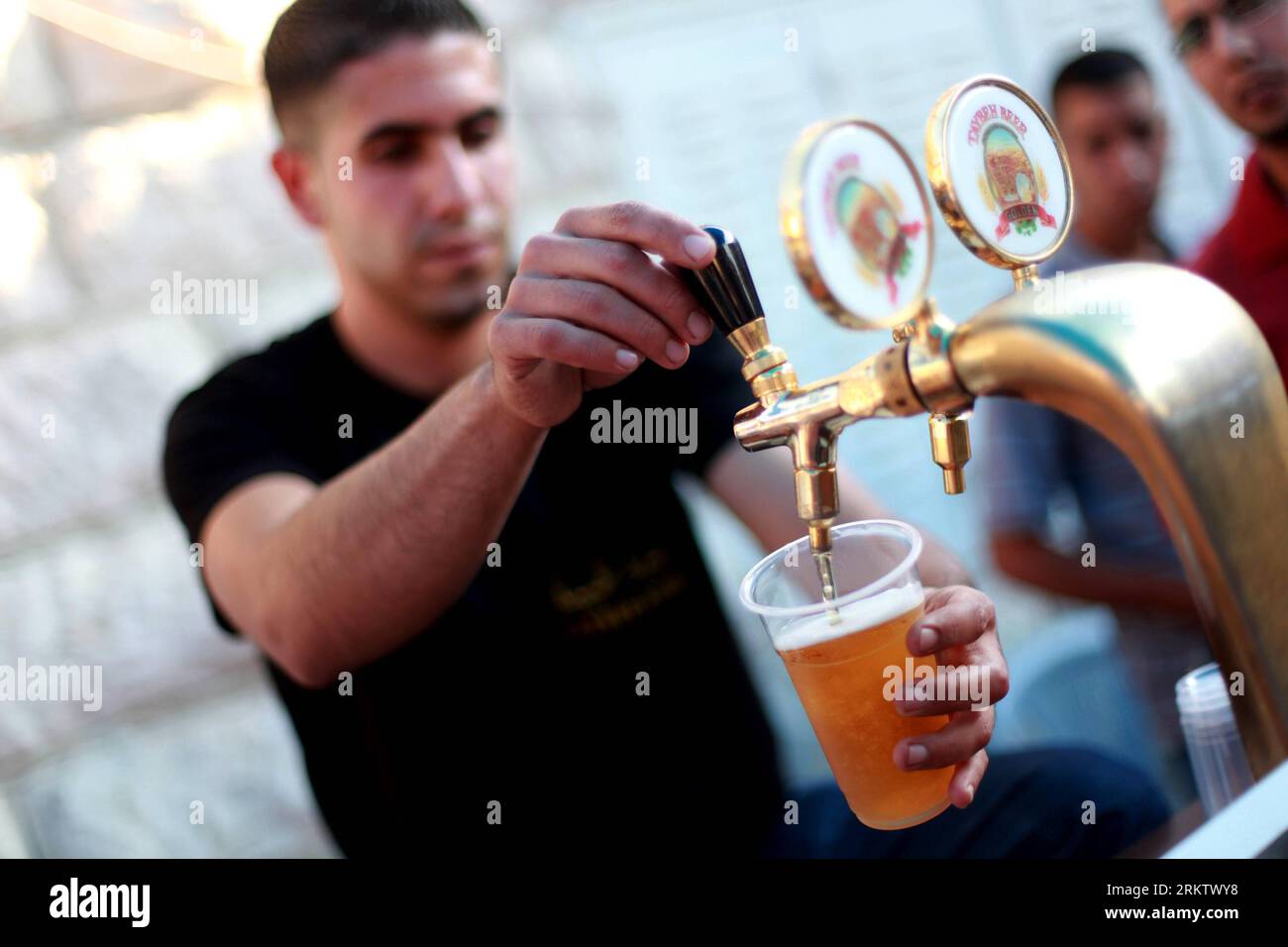 Bildnummer: 58561120  Datum: 06.10.2012  Copyright: imago/Xinhua A Palestinian pours Beer during the 2012 Taybeh Oktoberfest beer festival in the West Bank Christian village of Taybeh, near Ramallah, on Oct. 6, 2012. The annual beer festival is put on by the Taybeh brewery, the only such establishment in the predominantly Muslim Palestinian territories. (Xinhua/Fadi Arouri) MIDEAST- RAMALLAH- OKTOBERFEST- BEER PUBLICATIONxNOTxINxCHN Gesellschaft Alkohol Zapfhahn Becher Bierbecher Bierzapfen Objekte x0x xds 2012 quer     58561120 Date 06 10 2012 Copyright Imago XINHUA a PALESTINIAN pour Beer du Stock Photo