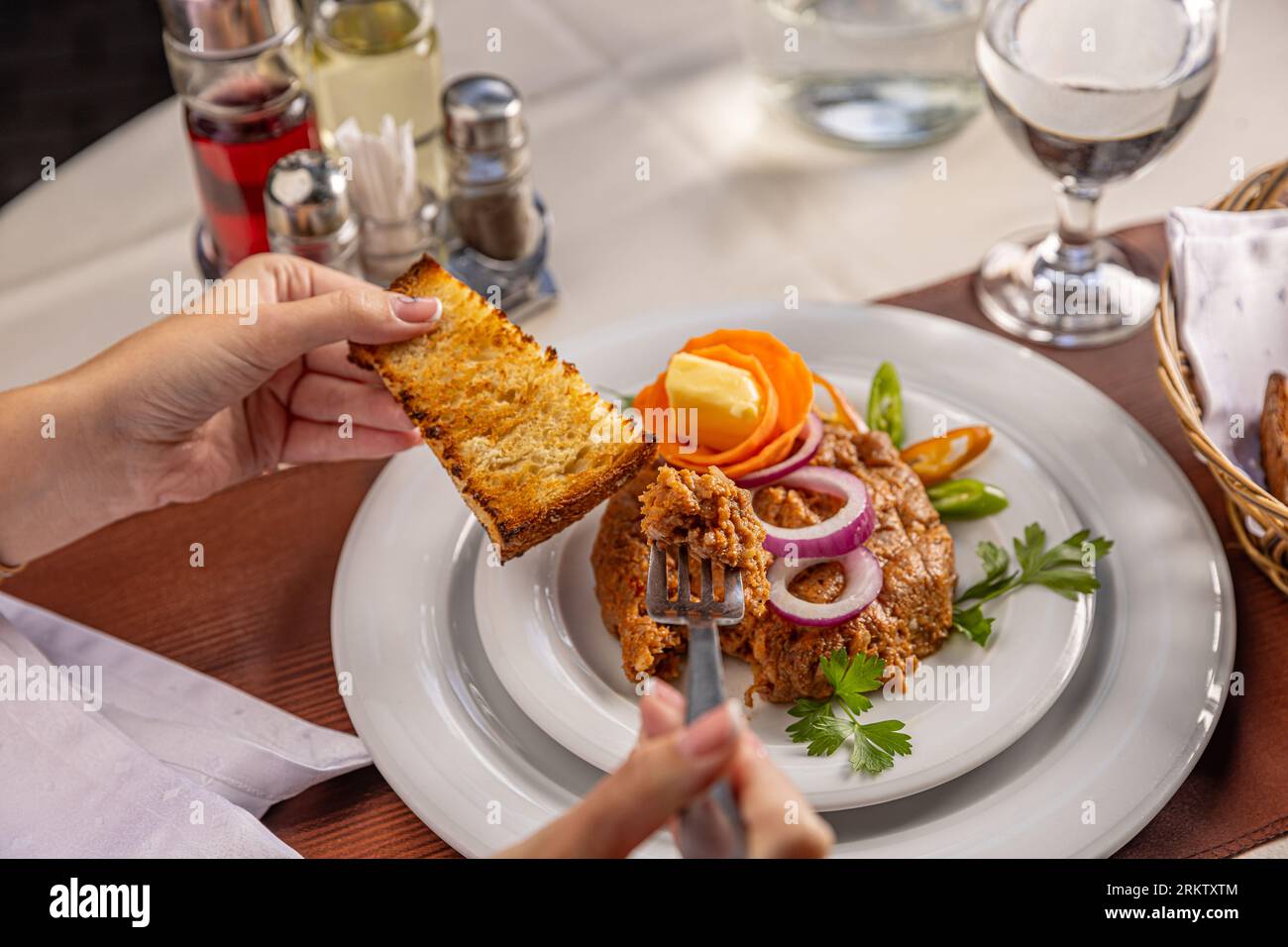Beefsteak tartar with red onion rings ready to eat with toasted bread ...