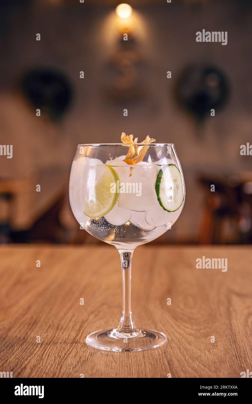Alcohol refreshing cocktail with lemon and cucumber in glass goblet Stock Photo