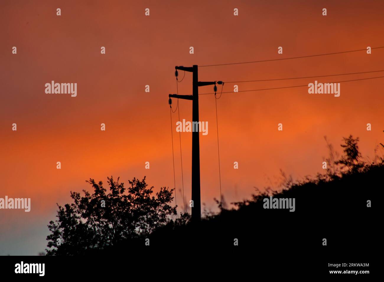 palo dell'elettricità contro un cielo arancio Stock Photo