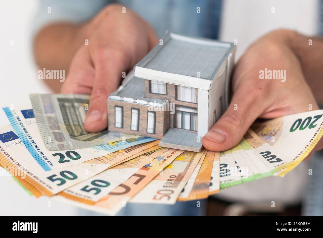 Real estate agent holding house model Stock Photo - Alamy