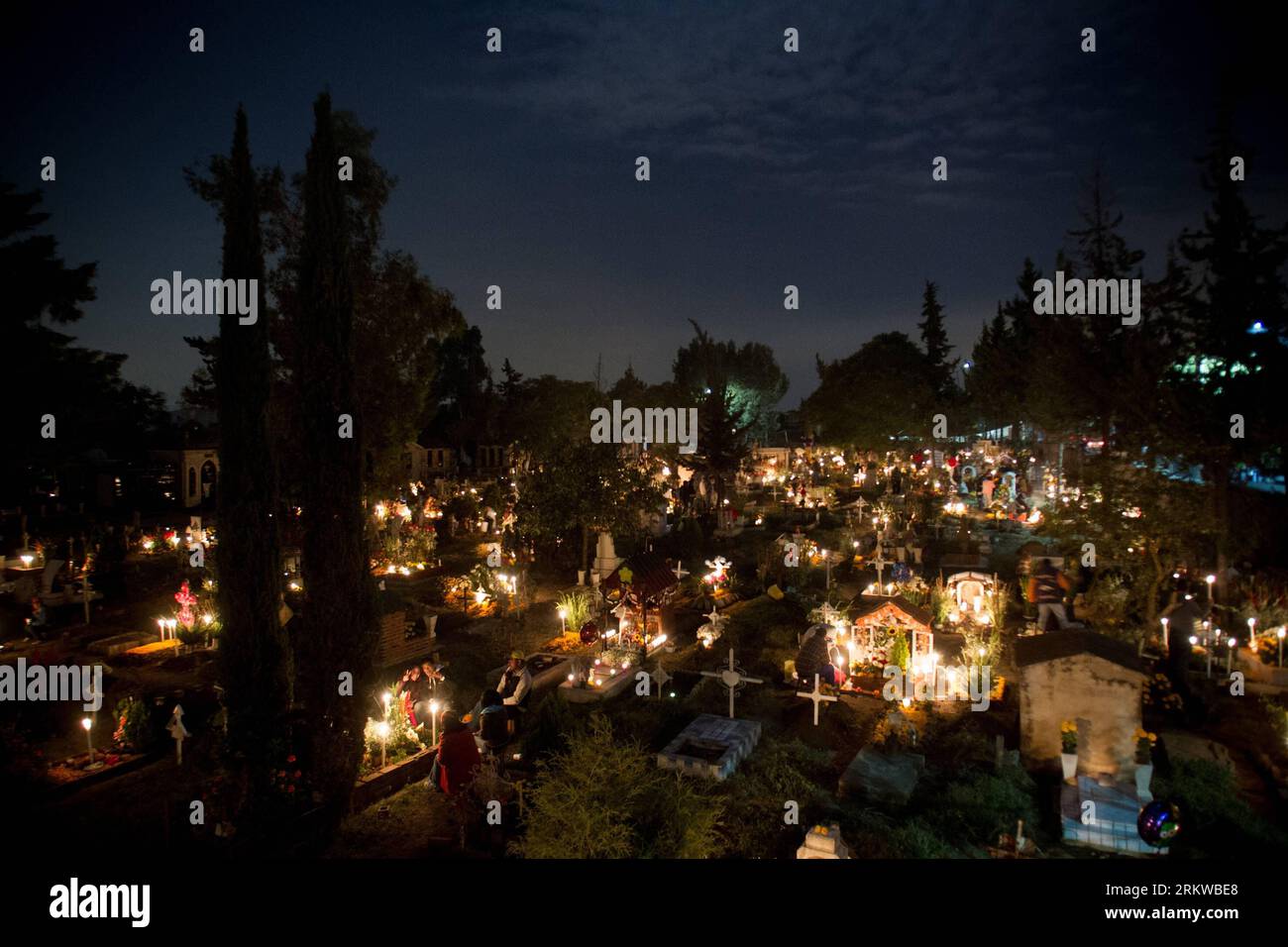 (121101) -- MEXICO CITY, Nov. 1, 2012 (Xinhua) -- Residents stay near to their relatives graves, during the Day of the Dead celebrations at the San Gregorio Burough Graveyard, in Xochimilco, Mexico City, capital of Mexico, on Nov. 1, 2012. The Day of the Dead is a Mexican celebration that has a prehispanic origin that honors the deceased adults on Nov. 2 and the deceased children on Nov. 1, this celebration matches with the catholic holidays of the Day of the Faithful Deceased and the Day of All the Saints. (Xinhua/Pedro Mera)(zyw) MEXICO-MEXICO CITY-SOCIETY-DAY OF THE DEAD PUBLICATIONxNOTxINx Stock Photo