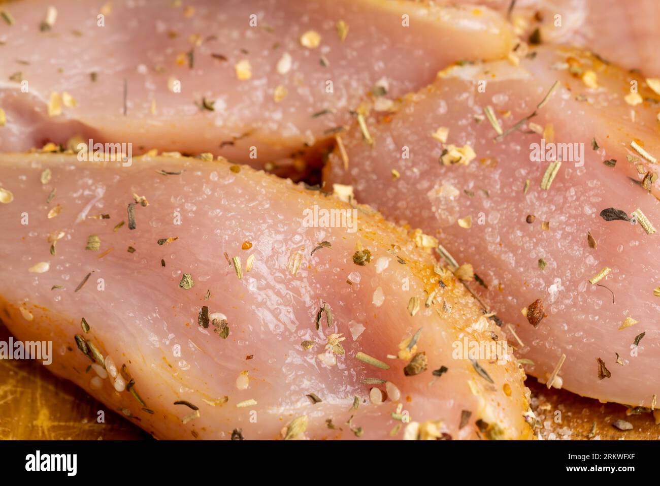 Freshly washed and skinned chicken meat, chicken fillets with salt and spices ready for cooking Stock Photo