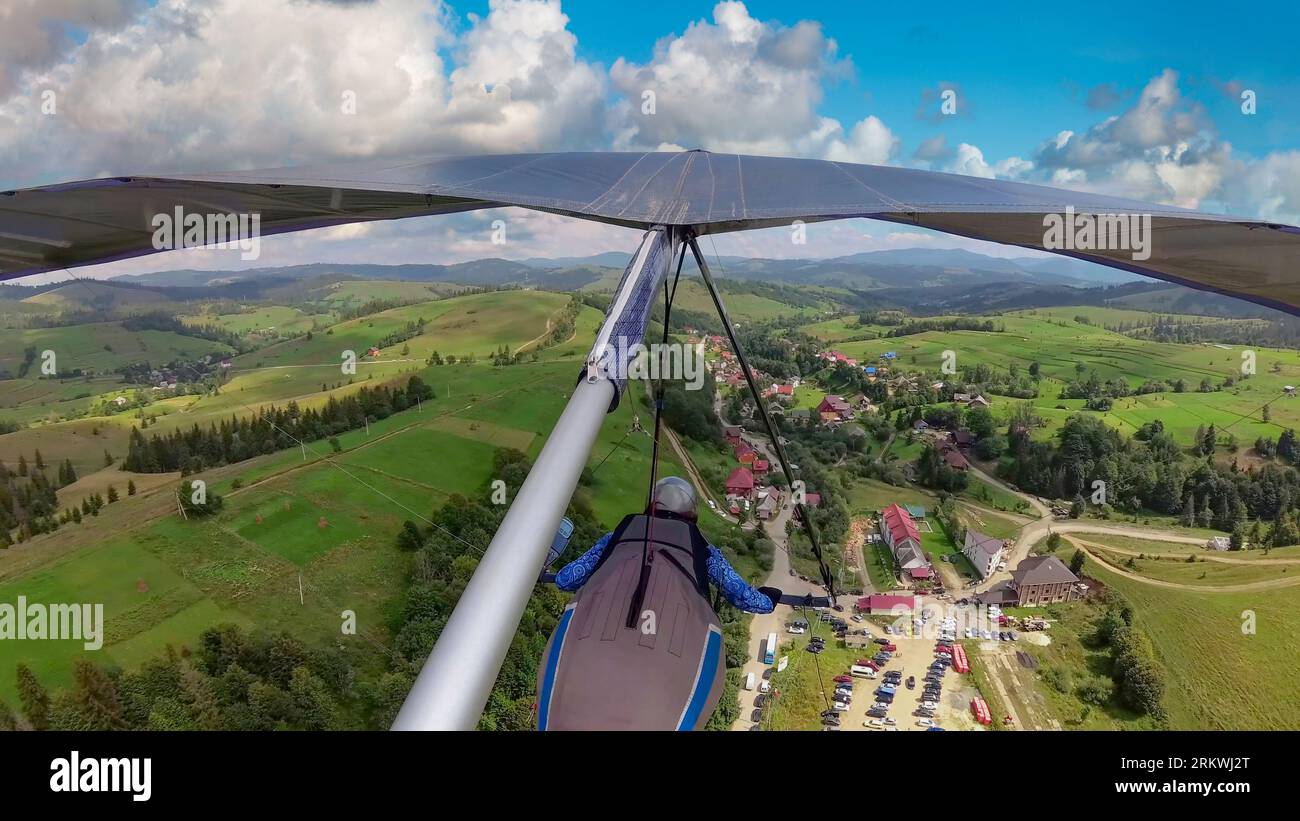 Hang glider pilot flying in the highlands. POV photo from onboard action camera Stock Photo