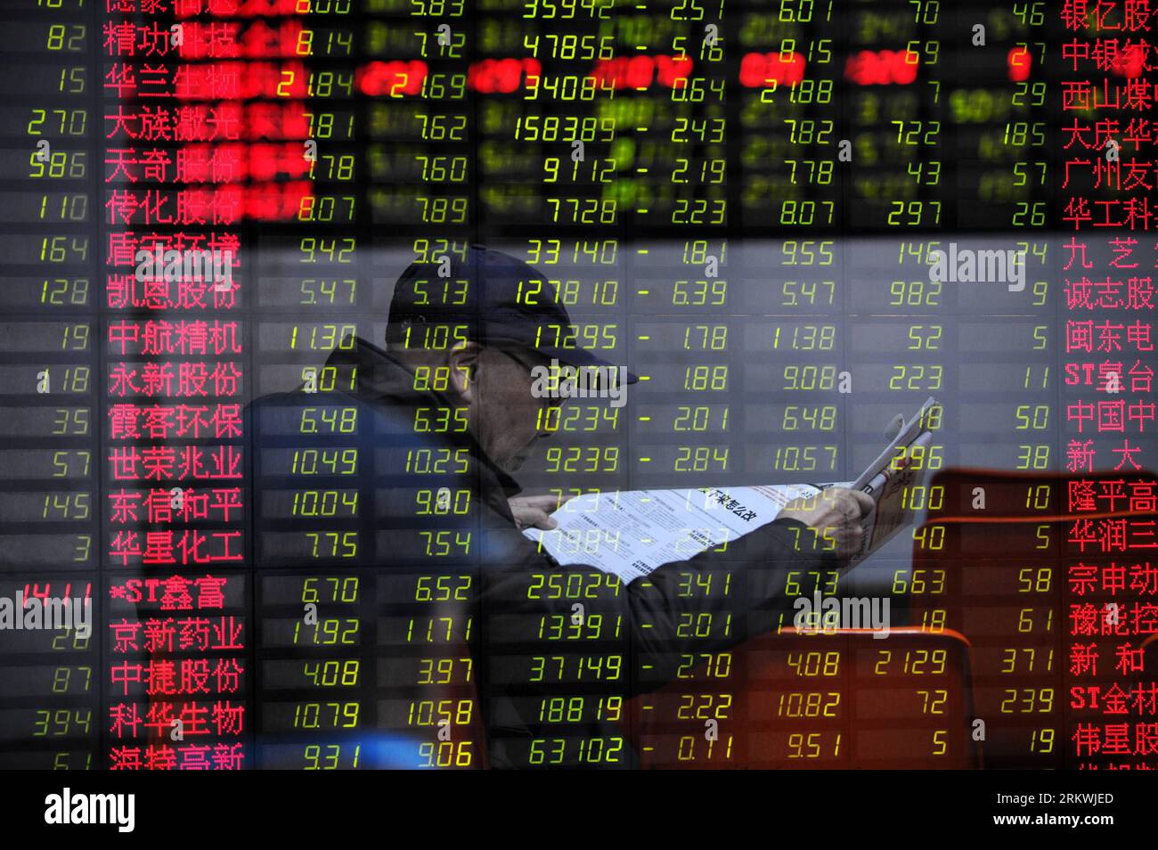 Bildnummer: 58696475  Datum: 13.11.2012  Copyright: imago/Xinhua (121113) -- HANGZHOU, Nov. 13, 2012 (Xinhua) -- An investor reads newspaper before the stock price monitor at a stock trading hall in Hangzhou, capital of east China s Zhejiang Province, Nov. 13, 2012. Chinese stocks experienced a decline on Tuesday. The benchmark Shanghai Composite Index dropped 1.51 percent, to close at 2,047.89 points. The Shenzhen Component Index ended at 8,234.60 points, down 1.87 percent. (Xinhua/Ju Huanzong) (zc) CHINA-STOCKS-DOWN (CN) PUBLICATIONxNOTxINxCHN Wirtschaft Börse Kurs Aktien Aktienkurs Börsenku Stock Photo