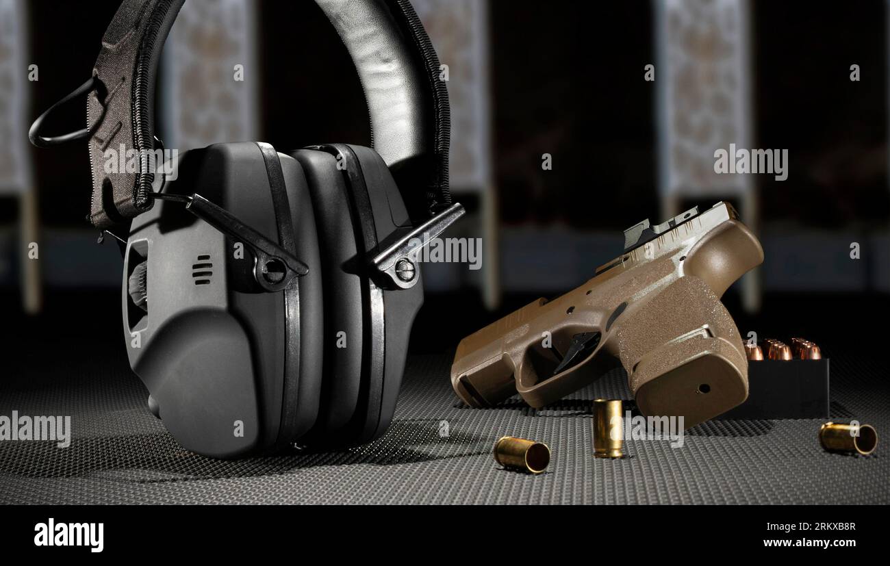 Automatic 9 mm pistol with ammo and electronic hearing protection on a