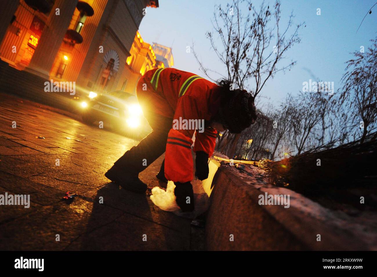 Bildnummer: 59095362  Datum: 16.01.2013  Copyright: imago/Xinhua HARBIN, Jan. 16, 2013 (Xinhua) -- Sanitation worker Yang Weixia stoops to pick up a plastic handbag on a road in Harbin, capital of northeast China s Heilongjiang Province, Jan. 16, 2013. Yang Weixia, 48, is an ordinary sanitation worker living in Harbin, a city known for its bitterly cold winters and often called the Ice City. For 32 years, Yang has never stopped sweating away at her work, though she often gets up at three o clock every morning and will not go back home until 9 in the evening in the cold winter. There are more t Stock Photo