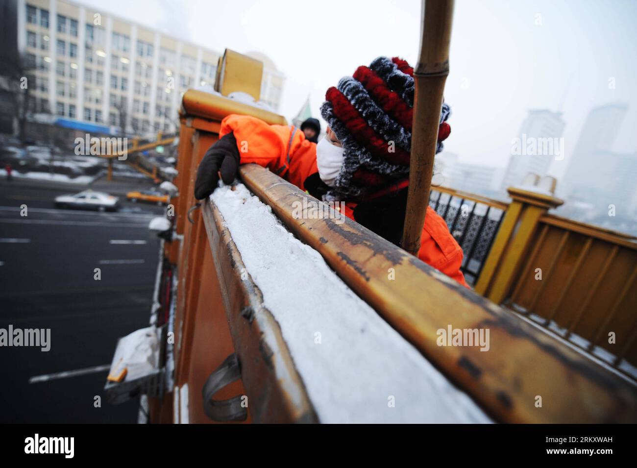 Bildnummer: 59095369  Datum: 16.01.2013  Copyright: imago/Xinhua HARBIN, Jan. 16, 2013 (Xinhua) -- Sanitation worker Yang Weixia picks up a cigarette end from a bridge handrail in Harbin, capital of northeast China s Heilongjiang Province, Jan. 16, 2013. Yang Weixia, 48, is an ordinary sanitation worker living in Harbin, a city known for its bitterly cold winters and often called the Ice City. For 32 years, Yang has never stopped sweating away at her work, though she often gets up at three o clock every morning and will not go back home until 9 in the evening in the cold winter. There are more Stock Photo