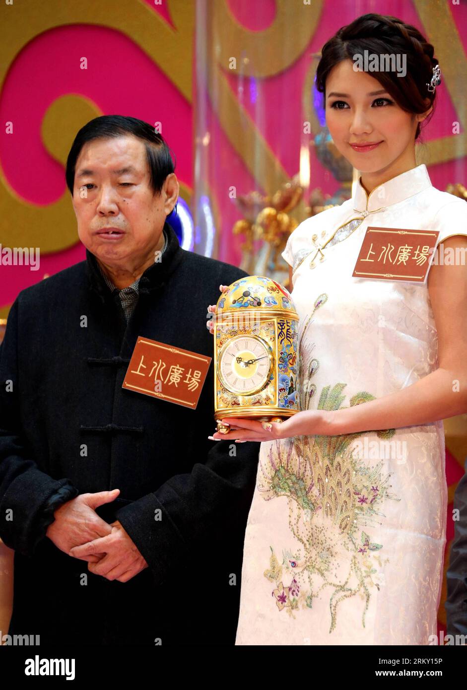 Bildnummer: 59117010  Datum: 22.01.2013  Copyright: imago/Xinhua (130122) -- HONG KONG, Jan. 22, 2013 (Xinhua) -- Artist Zhang Tonglu (L) looks on as a cloisonne clock he made is presented by Elva Ni, the winner of 2005 Miss Chinese Toronto Pageant, during an exhibition in south China s Hong Kong, Jan. 22, 2013. An exhibition of Zhang Tonglu s cloisonne art works was held here on Tuesday, showing 22 pieces of cloisonne works. (Xinhua/Li Peng) (xzj) CHINA-HONG KONG-CLOISONNE-EXHIBITION (CN) PUBLICATIONxNOTxINxCHN Kultur Entertainment People Schönheitskönigin Handwerk Kunst Kunsthandwerk Exponat Stock Photo