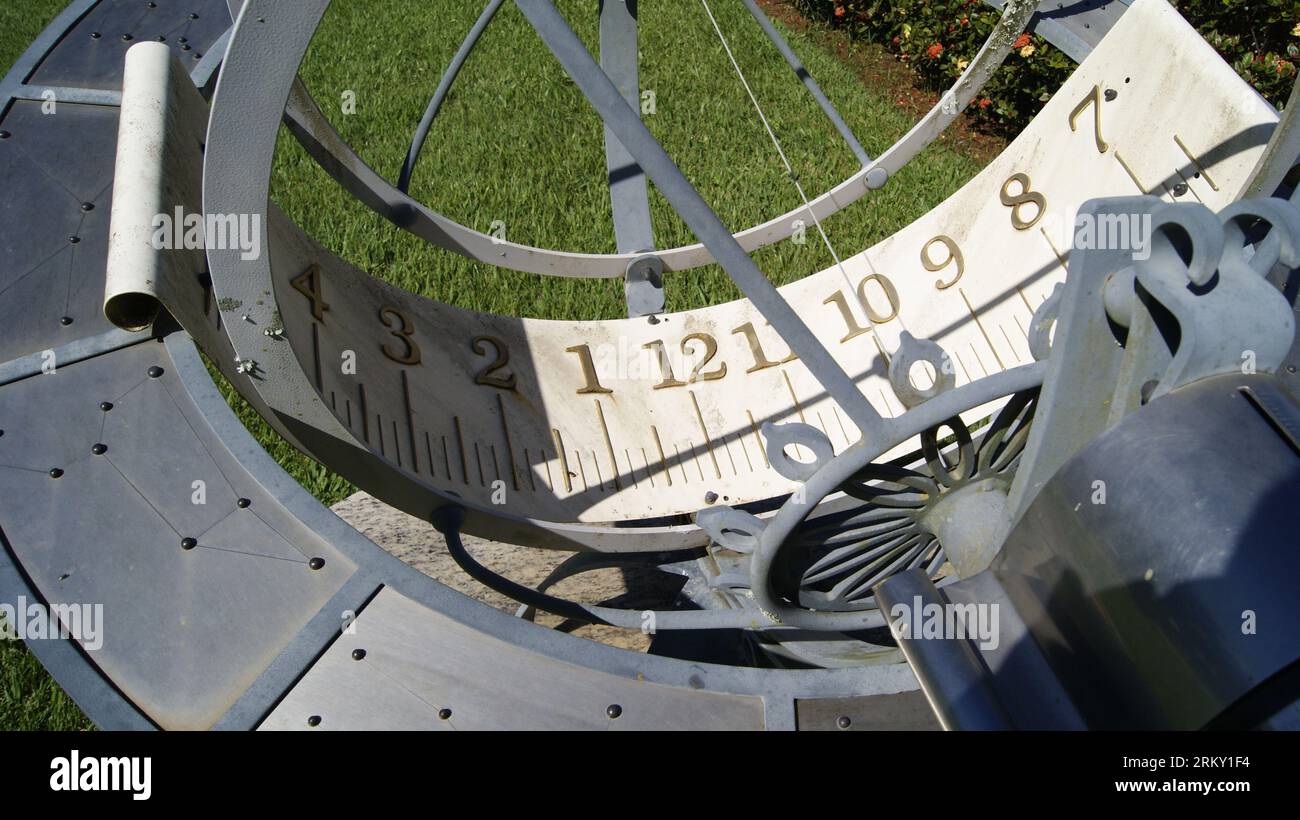 Sundial built in grassy garden showing numbers. Photo zoom with selective focus Stock Photo
