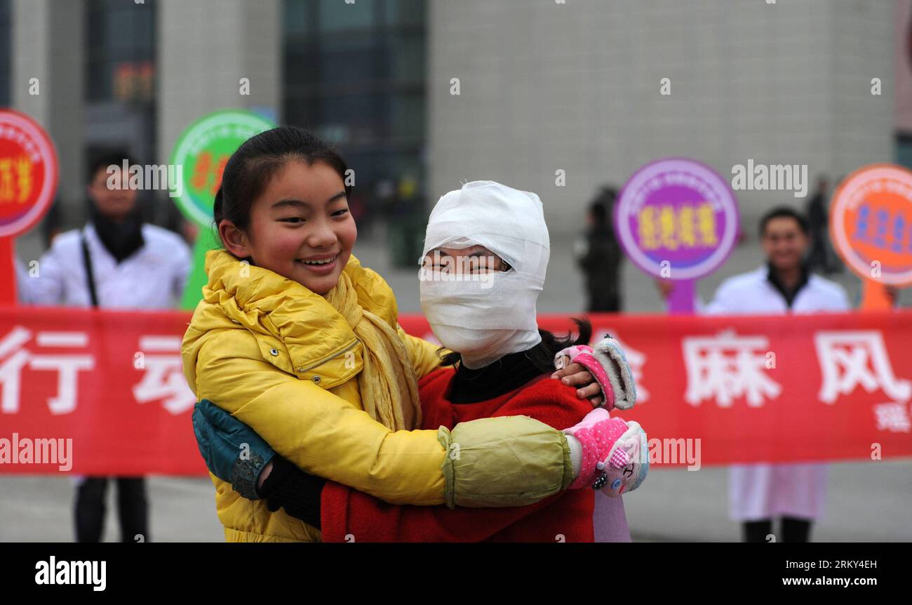 130127 -- HEFEI, Jan. 27, 2013 Xinhua -- A passerby hugs with a a staff member dressed like a leprosy patient with bandage on the square of the Hefei Railway Station in Hefei, capital of east China s Anhui Province, Jan. 27, 2013. Staff members from a local center for disease control and prevention carried out a campaign to promote leprosy prevention here on Sunday, the 60th World Leprosy Day. Xinhua/Liu Junxi xzj CHINA-ANHUI-HEFEI-LEPROSY PREVENTION CN PUBLICATIONxNOTxINxCHN Stock Photo