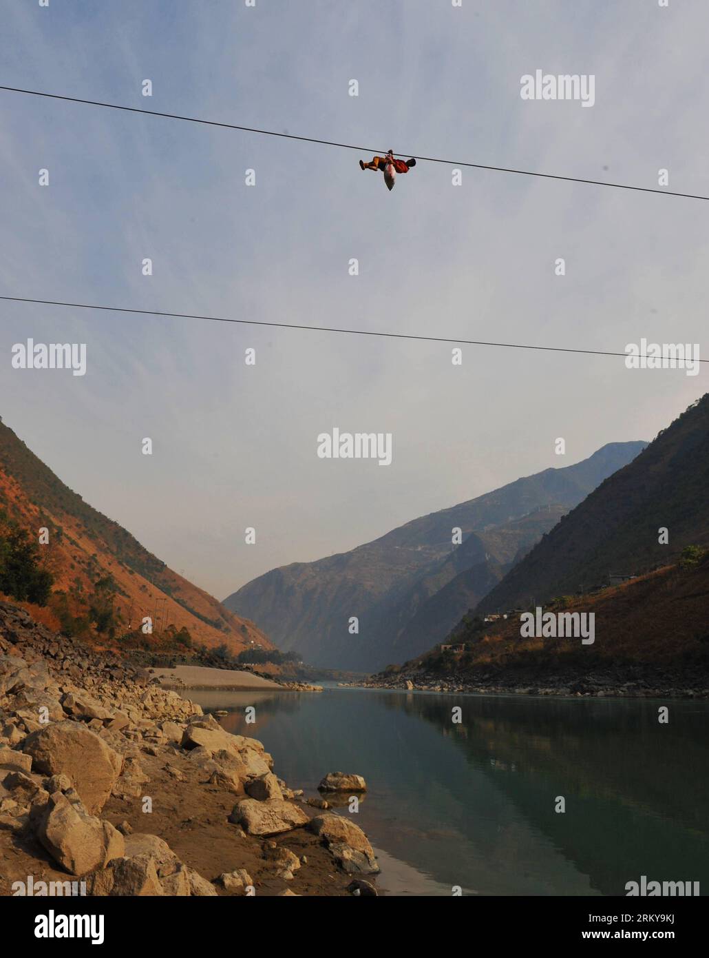 Bildnummer: 59176874  Datum: 02.02.2013  Copyright: imago/Xinhua (130205) -- KUNMING, Feb. 2, 2013 (Xinhua) -- A resident from Shuangmidi Village crosses the Nujiang River via a zip-line in Liuku County of Nujiang Lisu Autonomous Prefecture, southwest China s Yunnan Province, Feb. 2, 2013. More than 98 percent of Nujiang Lisu Autonomous Prefecture is occupied by mountains and valleys. The zip-lines have been quite popular transportation method along the Nujiang River since the ancient time. However, as transport conditions improve in recent years, a growing number of traditional zip-lines alon Stock Photo