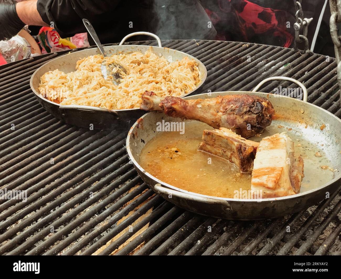 chicken thighs fillet rice cooked on fire in metal plates ,heat the
