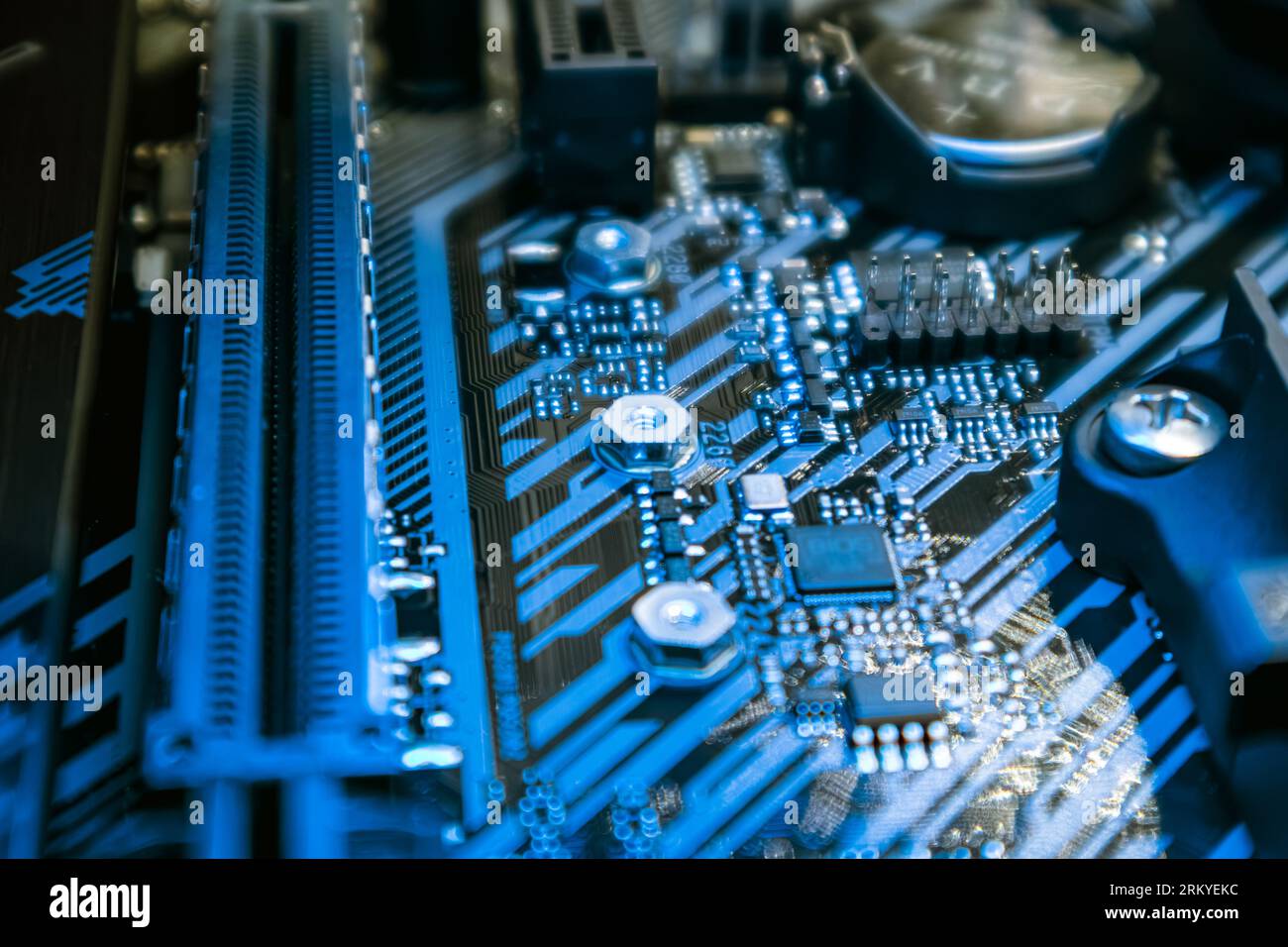 Motherboard with sockets and microchips close-up on modern powerful desktop PC in blue light. Computer hardware chipset components. Tech industry elec Stock Photo