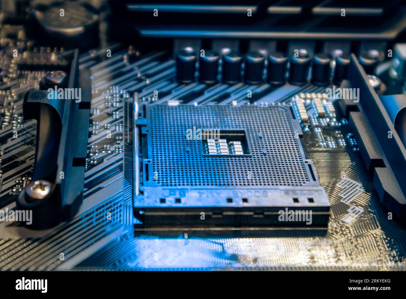 Powerful desktop PC motherboard with AM4 CPU Socket. Computer hardware chipset components close-up in blue light. Tech industry electronics background Stock Photo