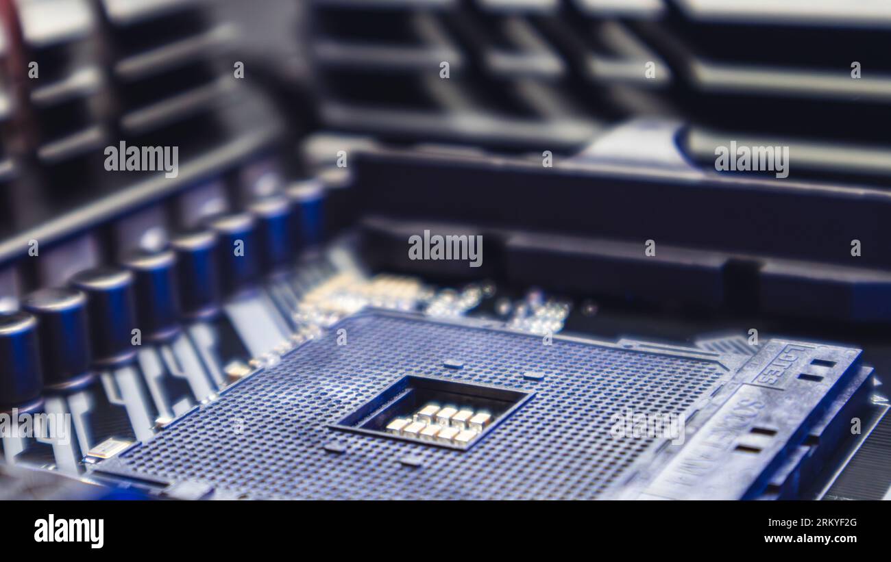 AM4 CPU Socket on motherboard of modern powerful PC. Desktop computer hardware chipset components close-up in blue light. Tech industry electronics ba Stock Photo