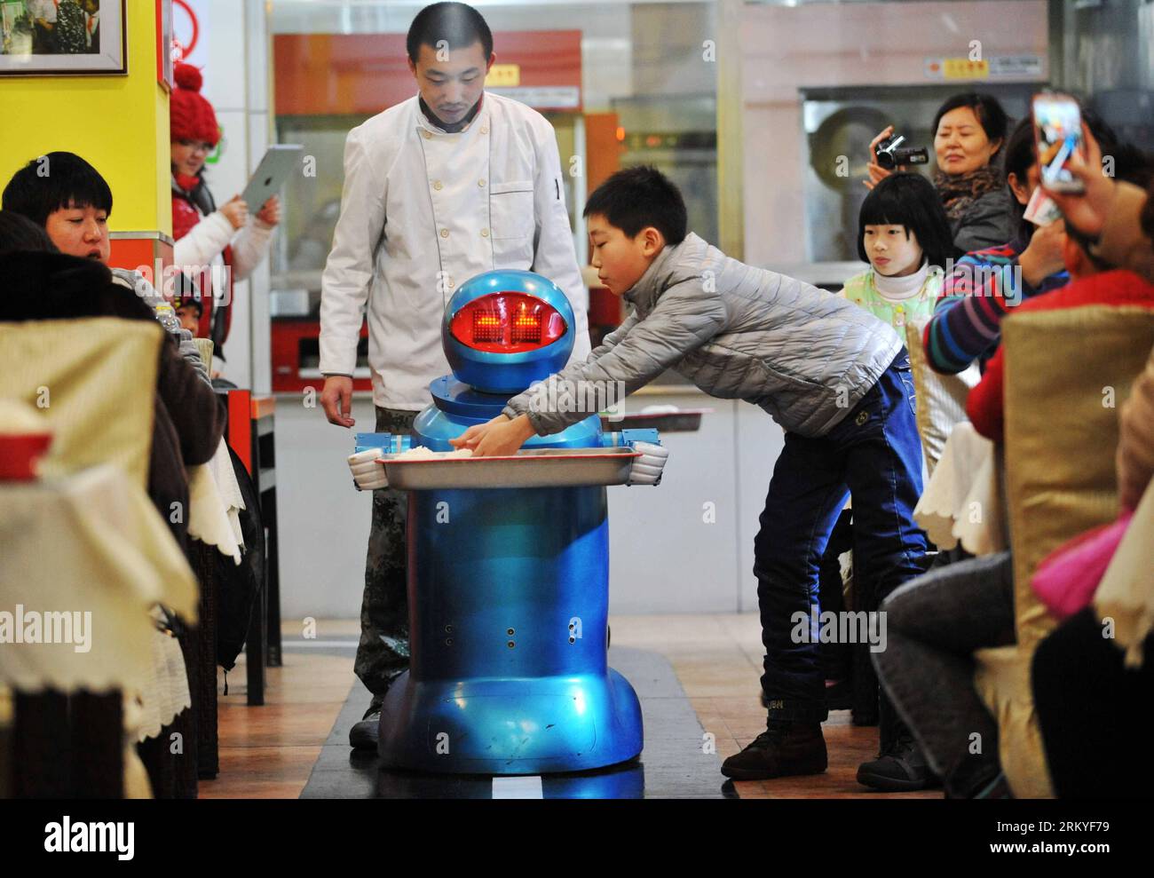 Bildnummer: 59214294  Datum: 13.02.2013  Copyright: imago/Xinhua (130213) -- HARBIN, Feb. 13, 2013 (Xinhua) -- A robot waiter brings Jiaozi, or Chinese dumplings, to a consumer in a restaurant in Harbin, capital of northeast China s Heilongjiang Province, Feb. 13, 2013. The restaurant, offering service by 20 robots, started operating on Wednesday, attracting many consumers. (Xinhua/Wang Jianwei) (hdt) CHINA-HARBIN-RESTAURANT-ROBOT (CN) PUBLICATIONxNOTxINxCHN Gesellschaft Gastronomie Erlebnisgastronomie kurio Komik Roboter Kellner Fotostory premiumd x0x xac 2013 quer      59214294 Date 13 02 20 Stock Photo