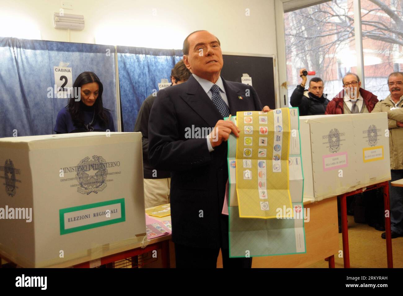 Italian Premier Silvio Berlusconi holds up a broom during his