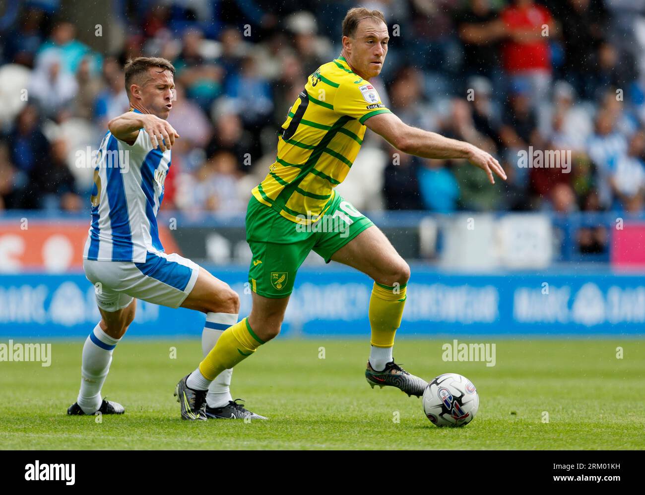 Norwich City's Ashley Barnes (right) and Huddersfield Town's Jonathan Hogg battle for the ball during the Sky Bet Championship match at the John Smith's Stadium, Huddersfield. Picture date: Saturday August 26, 2023. Stock Photo