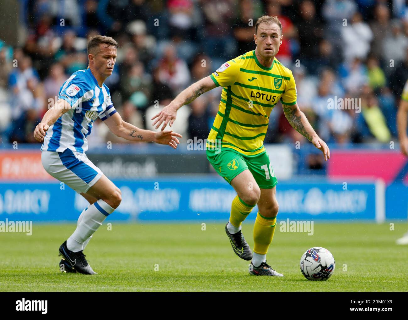 Norwich City's Ashley Barnes (right) and Huddersfield Town's Jonathan Hogg battle for the ball during the Sky Bet Championship match at the John Smith's Stadium, Huddersfield. Picture date: Saturday August 26, 2023. Stock Photo