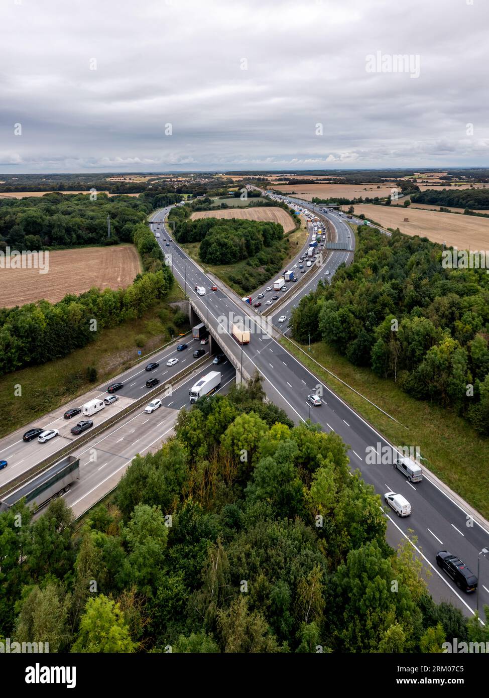 Aerial vertorama landscape of a busy stretch of the M1 motorway at a junction with traffic queuing and merging onto the main carriageway Stock Photo