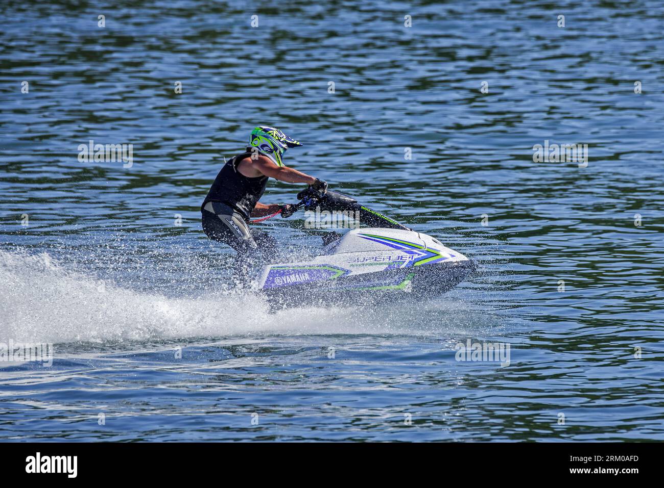 Jet ski / jetski / water scooter / stand-up personal watercraft / PWC rider racing on lake Stock Photo