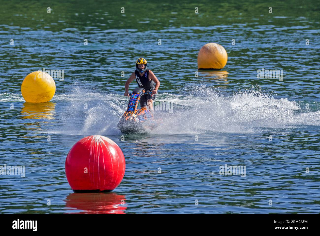 Jet ski / jetski / water scooter / stand-up personal watercraft / PWC rider slaloming along buoys on lake Stock Photo