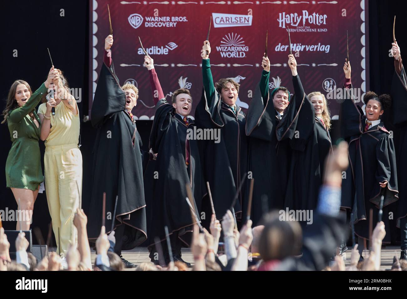 Hamburg, Germany. 26th Aug, 2023. Presenters Jana Riva (l) and Madita van Hülsen and performers stand on the stage at Rathausmarkt. Harry Potter celebrated its 25th anniversary with a world record attempt at the Rathausmarkt. More than 997 people dressed as Harry Potter were needed on the square to break the current record. Credit: Georg Wendt/dpa/Alamy Live News Stock Photo