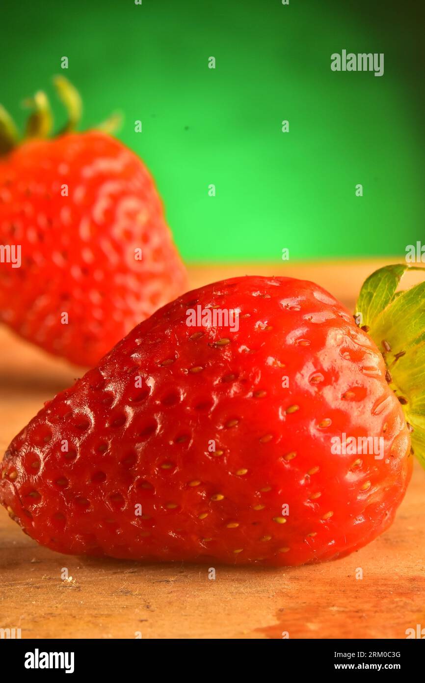 Strawberry fruit close up on studio shot, green background Stock Photo ...