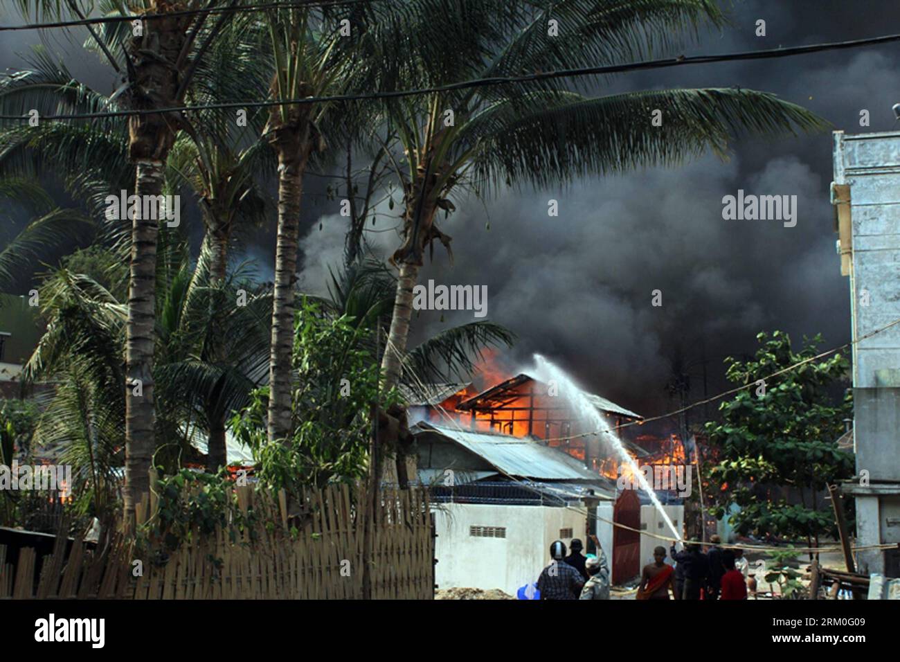 Bildnummer: 59411423  Datum: 22.03.2013  Copyright: imago/Xinhua (130322) -- MEIKHTILA (MYANMAR), March 22, 2013 (Xinhua) -- Firefighters try to extinguish a fire at a burning building during riots in Meiktila, Myanmar, March 22, 2013. Myanmar President U Thein Sein declared a state of emergency in four townships in Meikhtila District of Myanmar s northern Mandalay region as riot escalated after its outbreak on Wednesday. The Myanmar authorities confirmed Friday night that 11 have died and 39 injured in a communal riot in Meikthila over the last three days. (Xinhua/Sithu) MYANMAR-MEIKHTILA-RIO Stock Photo