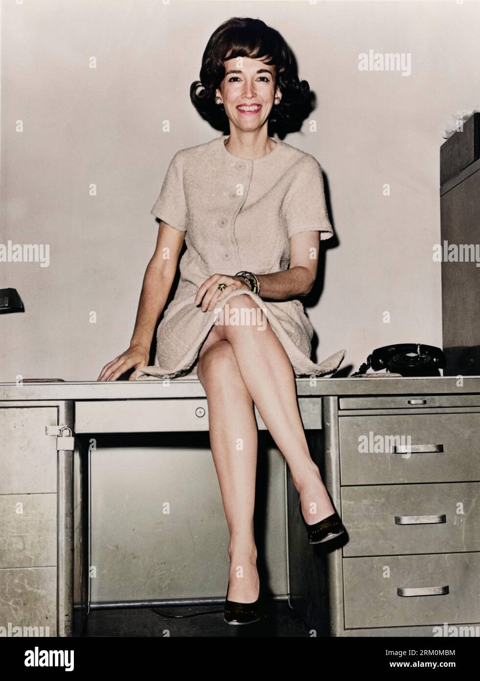 Helen Gurley Brown, full-length portrait, sitting on a desk in 1964. Stock Photo