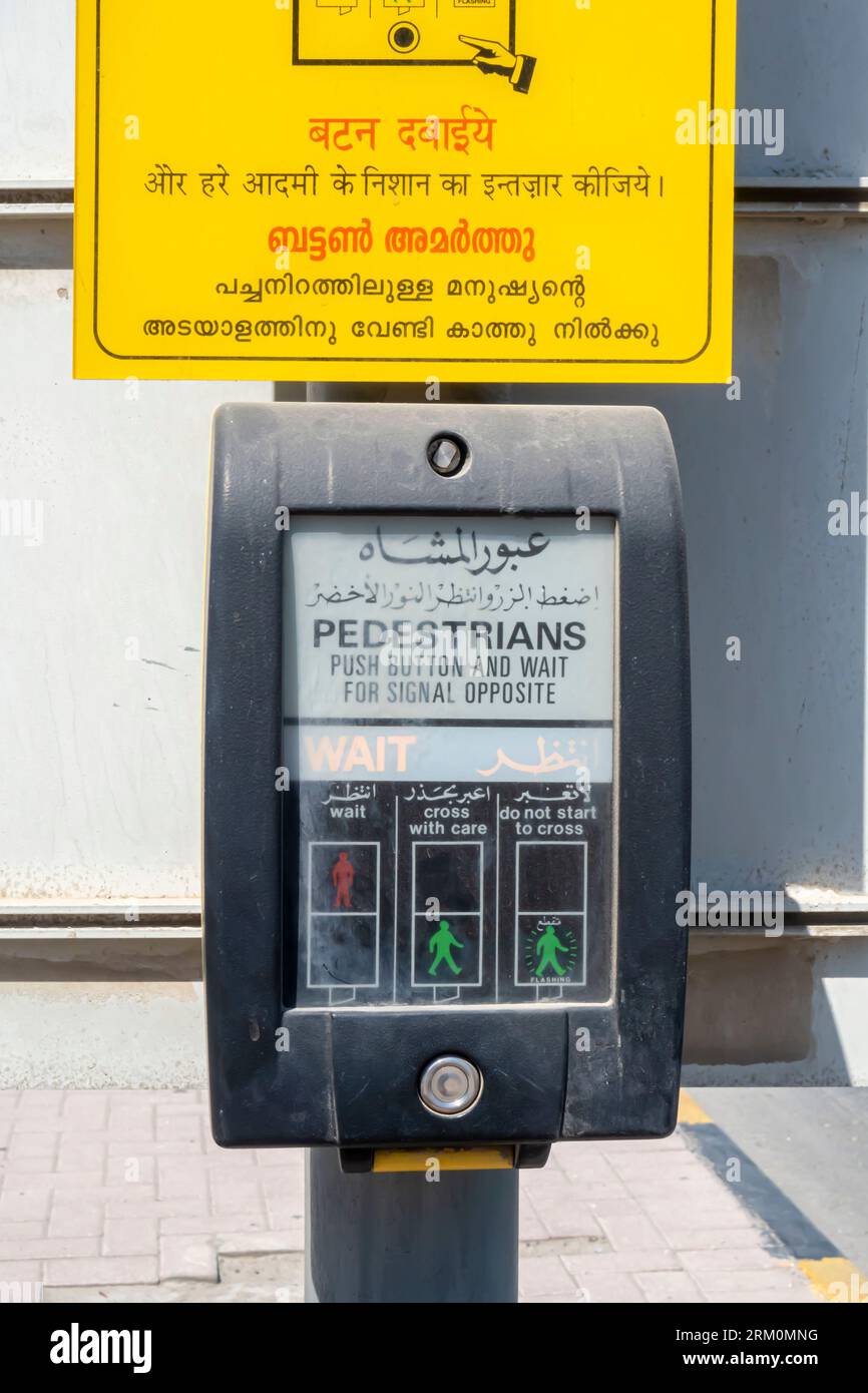 Push button crossing box for pedestrians in Bahrain Bilingual signs i nArabic, English, Hindu Stock Photo