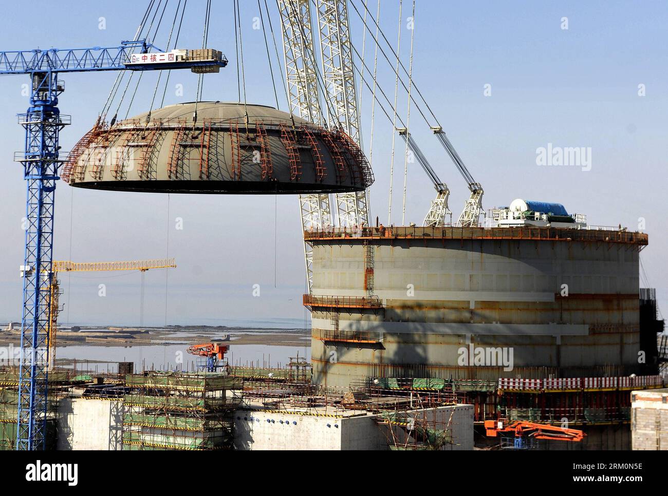 Bildnummer: 59457867  Datum: 29.03.2013  Copyright: imago/Xinhua (130329) -- HAIYANG, March 29, 2013 (Xinhua) -- A crane lifts the containment top head to cap the first unit of the Haiyang Nuclear Power Plant in Haiyang, east China s Shandong Province, March 29, 2013. The first unit of the Haiyang Nuclear Power Plant, which will be installed with the third generation of nuclear power technology, the AP1000, has seen completion of its civil construction on March 29. The unit is planned to come into stream at the end of 2014 with annual generation capacity of 17.5 billion Kwh. (Xinhua/Li Ziheng) Stock Photo