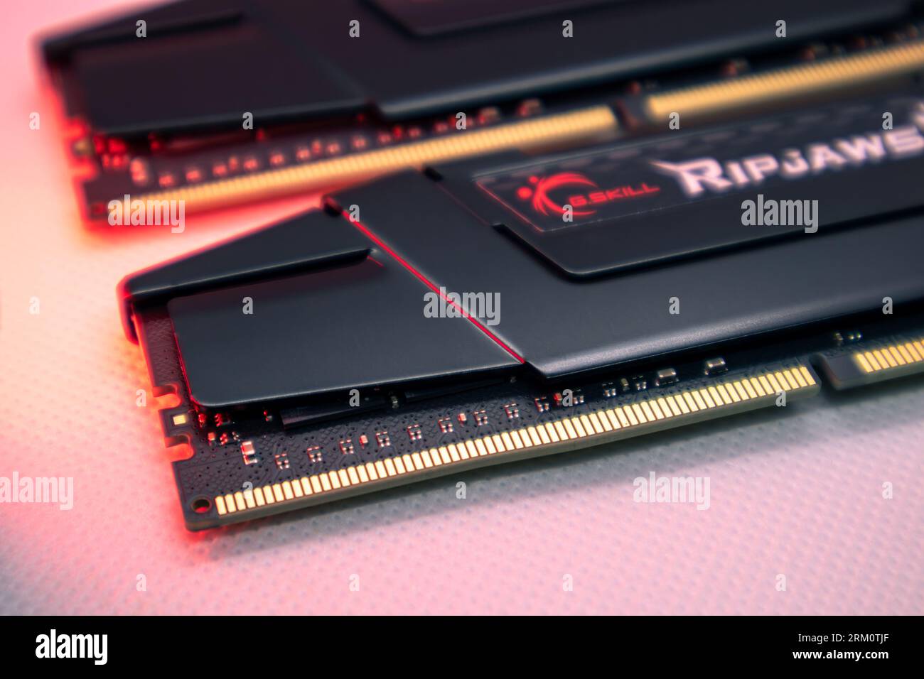 Kyiv, Ukraine - January 05, 2022: G.Skill Ripjaws V series DDR4 DRAM memory modules in red light. Computer RAM chip close-up on white. Desktop PC memo Stock Photo