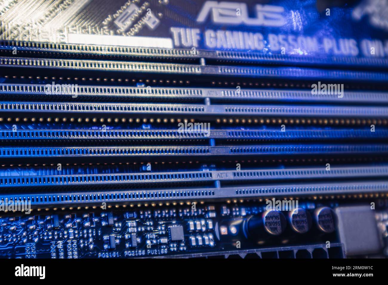 Kyiv, Ukraine - January 05, 2022: Asus Tuf Gaming motherboard, blue DDR RAM memory slots sockets close-up, desktop PC. Computer hardware chipset compo Stock Photo