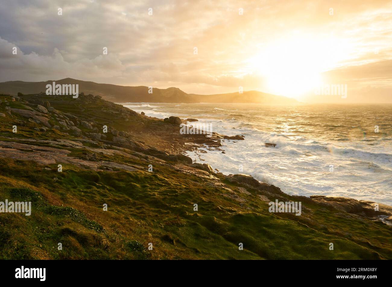 Rocky littoral of Costa da Morte coastline with rough sea at sunset (Muxía, Costa da Morte, Fisterra, A Coruña, Galicia, Atlantic Sea, Spain) Stock Photo
