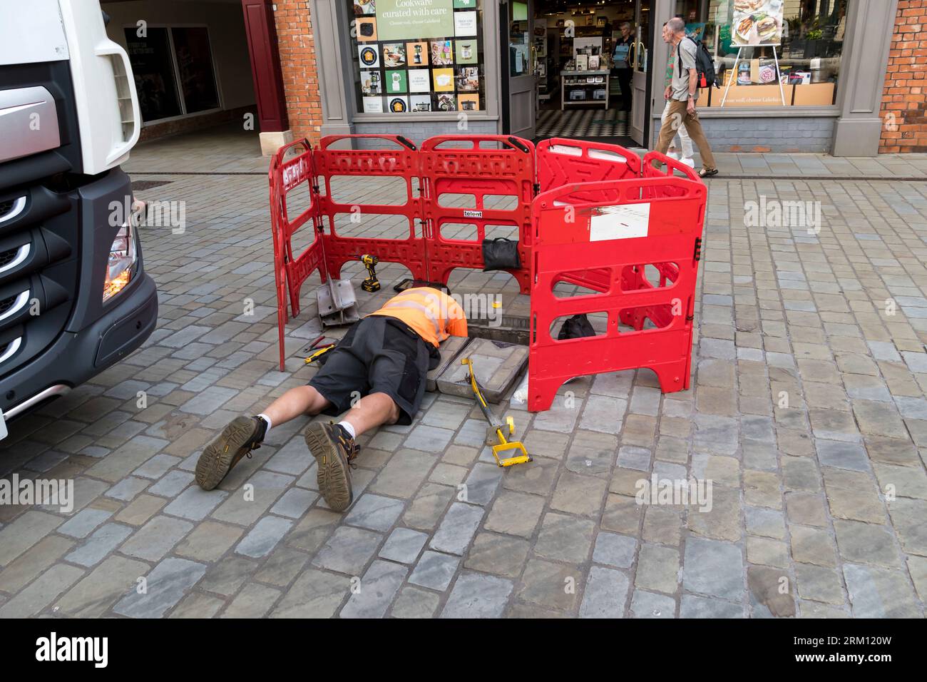 Telecoms engineer working in services manhole, Sincil Street, Lincoln City, Lincolnshire, England, UK Stock Photo