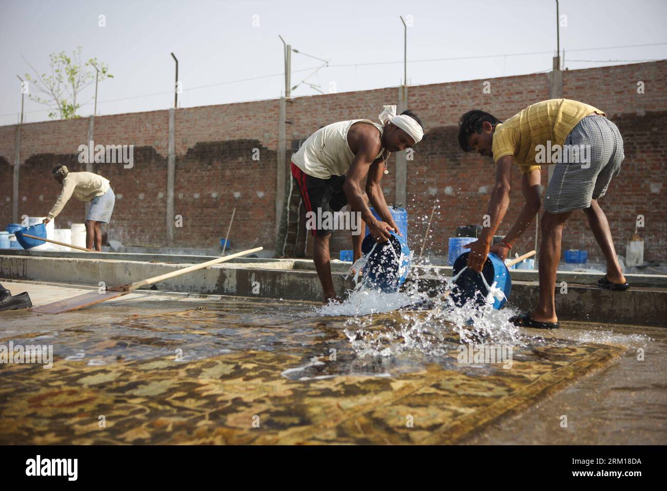 Bildnummer: 59537030  Datum: 17.04.2013  Copyright: imago/Xinhua (130418) -- BHADOHI, April 18, 2013 (Xinhua) -- Workers clean a handmade carpet in the factory of Bhadohi Carpets company in Bhadohi, Uttar Pradesh, India, April 17, 2013. More than 500 carpet manufacturing factories dotted the city of Bhadohi, which made the city the home to the largest hand-knotted carpet weaving industry hubs in South Asia. The carpet weaving in Bhadohi dates back to the 16th century, during the reign of Mughal Emperor, Akbar. According to Priyam Baranwal, parterner of Bhadohi Carpets Company, one of local lea Stock Photo