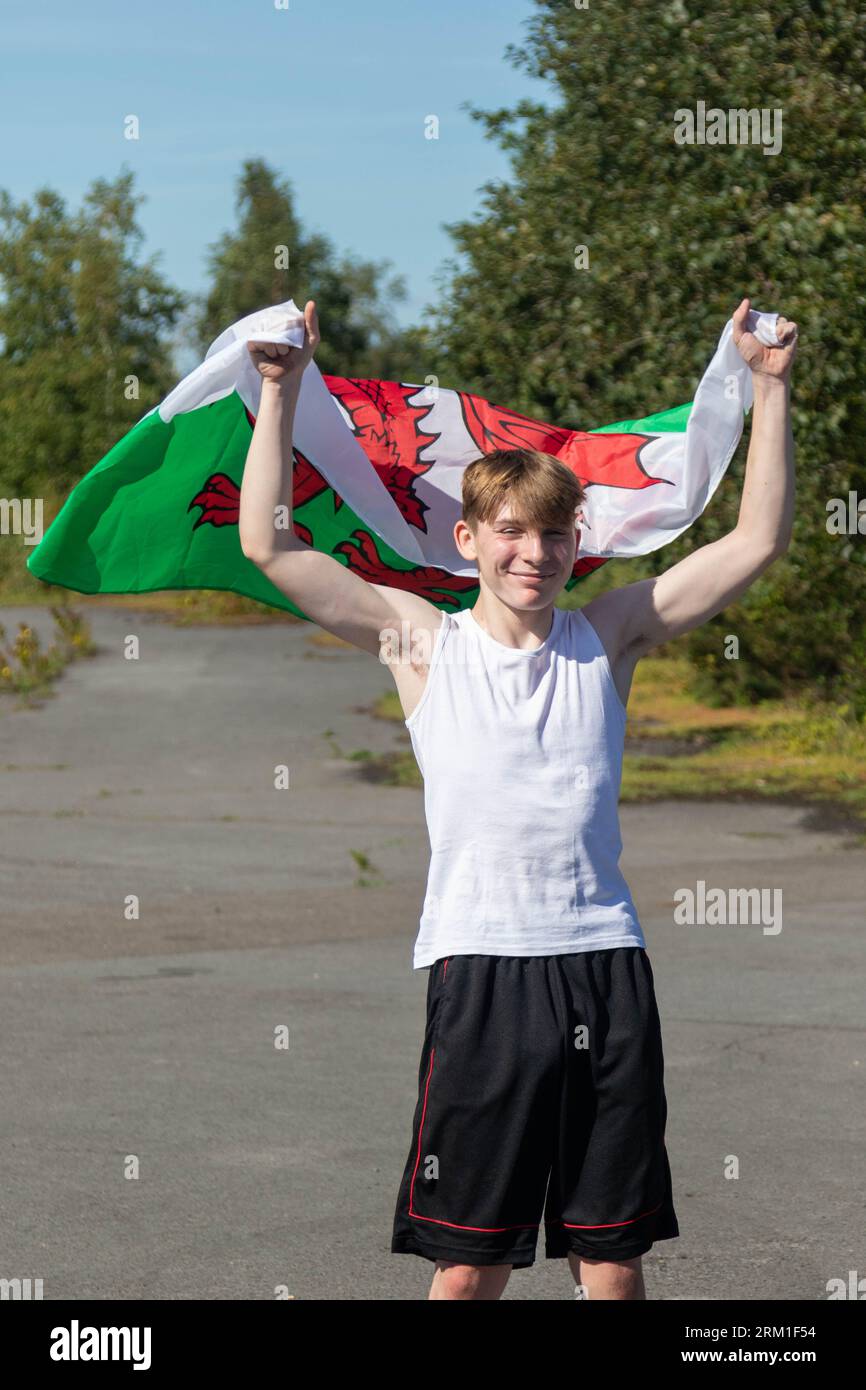 A happy and laughing teenage boy waving the Welsh Flag Stock Photo