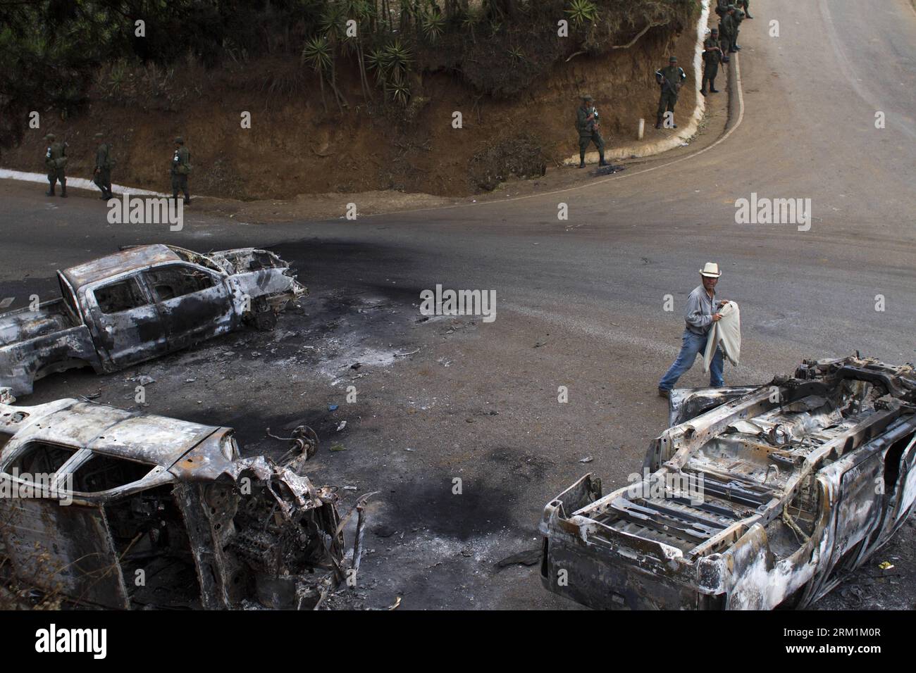Bildnummer: 59597625  Datum: 03.05.2013  Copyright: imago/Xinhua (130503) -- MATAQUESCUINTLA, May 3, 2013 (Xinhua) -- Members of Guatemalan Army stand guard around vehicles destroyed by residents in Mataquescuintla, township of the department of Jalapa, Guatemala, on May 2, 2013. The government of Guatemalan President OttoPerezMolina decreed a state of emergency in four townships Thursday roiled by protests against a mining company, which resulted in two deaths. (Xinhua/Luis Echeverria) (fnc) (sp) (syq) GUATEMALA-MATAQUESCUINTLA-SECURITY-VIOLENCE PUBLICATIONxNOTxINxCHN xcb x2x 2013 quer premiu Stock Photo
