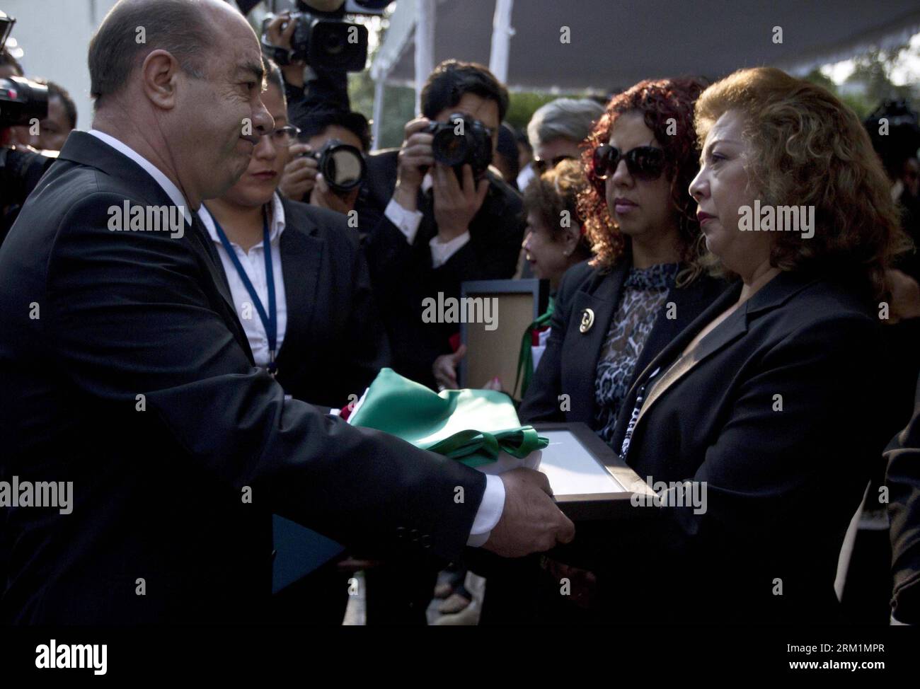 Bildnummer: 59602245  Datum: 04.05.2013  Copyright: imago/Xinhua (130504) -- MEXICO CITY, May 4, 2013 (Xinhua) -- Mexico s General Attorney Jesus Murillo Karam (L Front) hands over a national flag to a relative of one of the agents killed in an airplane crash, during a funeral ceremony in Mexico City, capital of Mexico, on May 4, 2013. Mexico s General Attorney s Office (PGR, for its acronym in Spanish) held a funeral ceremony to honor the six victims aboard a PGR s airplane which crashed on April 30, in Zacatecas, northern Mexico. (Xinhua/Rodrigo Oropeza) MEXICO-MEXICO CITY-FUNERAL PUBLICATIO Stock Photo