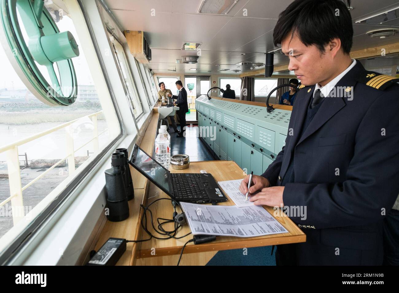 Bildnummer: 59604345  Datum: 24.04.2013  Copyright: imago/Xinhua NANJING, 2013 - Zhu Hui notes down Maple Star s technical data before setting sail from the port of Jingjiang in east China s Jiangsu Province, April 24, 2013. Wang Lianmiao and Zhu Hui arrived at the port of Jingjiang on the morning of April 24, 2013. Both men are inland waterway pilots from the Yangtze River Pilot Centre. Awaiting them was the Maple Star, a 180-meter-long Marshall Islands-flagged cargo ship with a gross register tonnage of over 23,000. Under their pilotage, the Maple Star was to veer 180 degrees and head downst Stock Photo