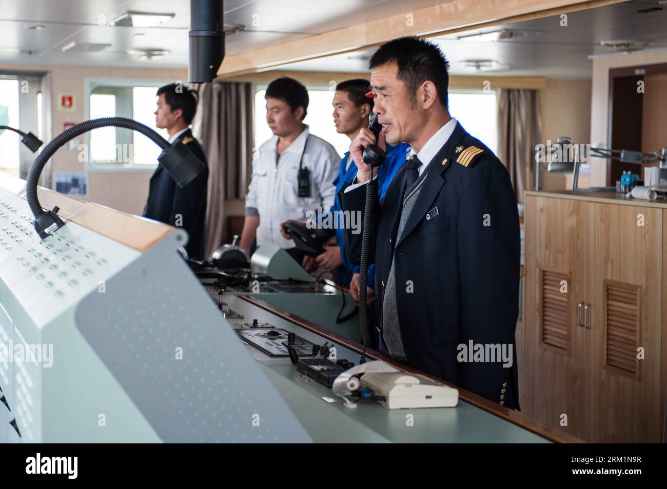 Bildnummer: 59604347  Datum: 24.04.2013  Copyright: imago/Xinhua NANJING, 2013 -- Wang Lianmiao (1st R) contacts nearby ships via high frequency radio aboard the Maple Star on the Yangtze River in east China s Jiangsu Province, April 24, 2013. Wang Lianmiao and Zhu Hui arrived at the port of Jingjiang on the morning of April 24, 2013. Both men are inland waterway pilots from the Yangtze River Pilot Centre. Awaiting them was the Maple Star, a 180-meter-long Marshall Islands-flagged cargo ship with a gross register tonnage of over 23,000. Under their pilotage, the Maple Star was to veer 180 degr Stock Photo