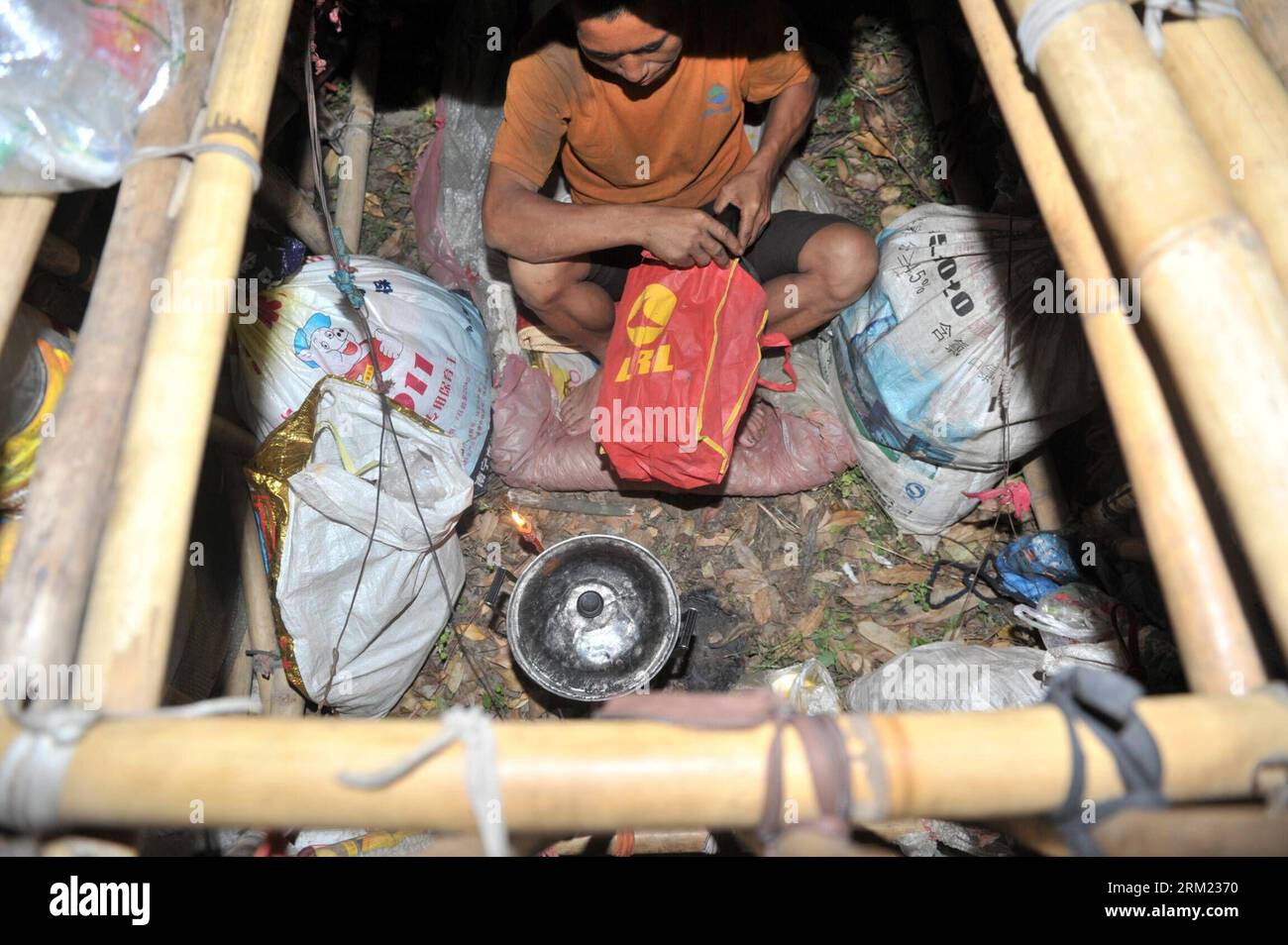 Bildnummer: 59677572  Datum: 21.05.2013  Copyright: imago/Xinhua LIUZHOU -- Liu Lingchao cooks in his moving hut on a road in Liucheng County of Liuzhou City, south China s Guangxi Zhuang Autonomous Region, May 21, 2013. Liu, a 38-year-old migrant worker from Liuzhou s Rong an County, decided to make a moving hut five years ago in Guangdong Province to live in on his way to Rong an, his hometown. The hut measures about 60 kilograms in weight, 1.5 meters in length and 2.2 meters in height. Since then, Liu has been carrying a hut and making a living by collecting rubbishes along the way. Having Stock Photo